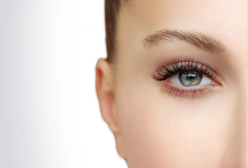 Close-up of a woman's eye showing the eyebrow, eyelashes, and smooth skin around the eye for SmoothEye laser tightening treatment.